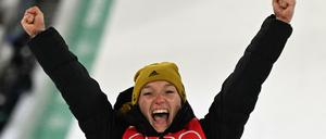 Skispringerin Katharina Althaus gewinnt die erste Medaille für Deutschland und jubelt bei der Siegerehrung über ihren zweiten Platz.