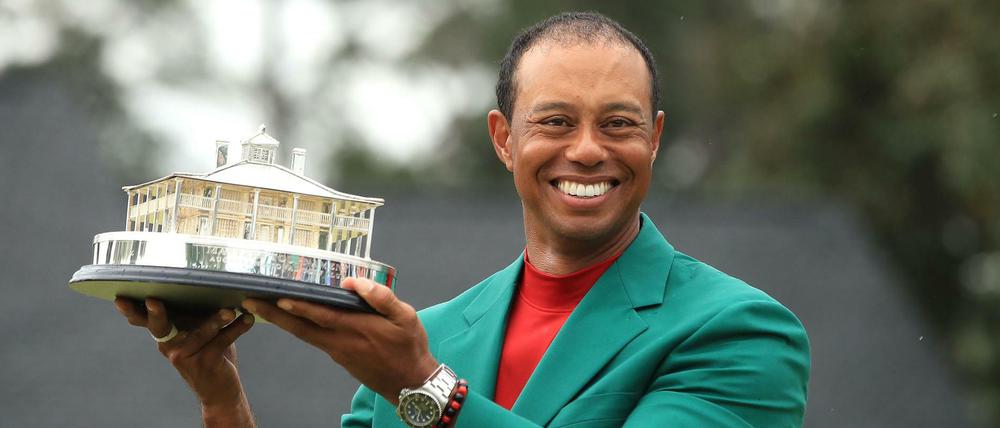 Gute Laune: Golfprofi Tiger Woods präsentiert im grünen Siegerjackett die Trophäe der Masters.