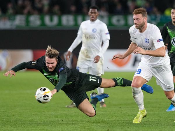Bild mit Symbolcharakter. Wolfsburgs Felix Klaus geht zu Boden.