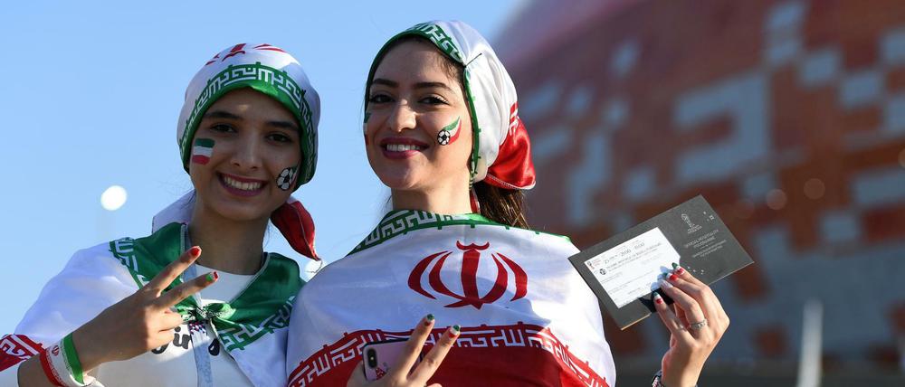 In Russland dabei. Zwei weibliche iranische Fans stehen bei der WM 2018 vor einem Stadion.