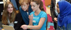 Bundeskanzlerin Angela Merkel spricht mit zwei Schülerinnen über das Programmieren