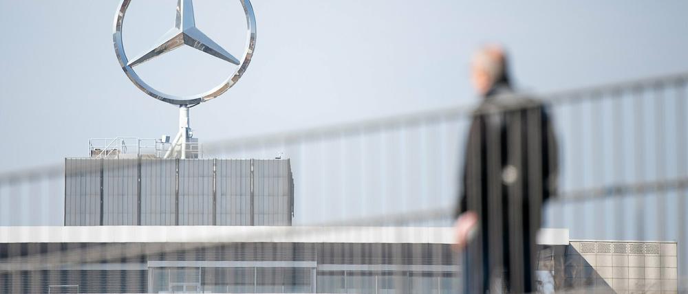 Ein Mitarbeiter von Daimler geht am Mercedes-Benz Werk Untertürkheim zum Schichtwechsel.
