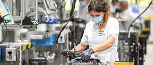 Eine Monteurin arbeitet in einem Werk des Automobilzulieferers ZF Friedrichshafen an ein Getriebe für Lastwagen. 