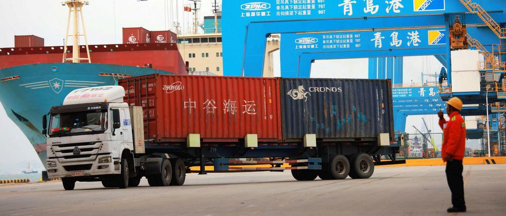 Im Hafen in Qingdao werden Container verladen. 