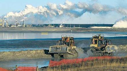 Zerstörte Landschaft. Bagger transportieren Ölsand in der Nähe von Fort McMurray in der kanadischen Provinz Alberta. Foto: AFP