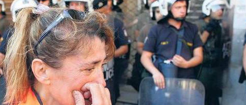 Tränen vor dem Innenministerium. Eine Mitarbeiterin des öffentlichen Dienstes demonstriert in Athen gegen Entlassungen und Sparpläne. 
