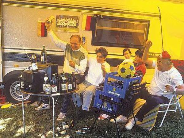 Fans vor der Röhre: Bei der WM 1990 konnten die Zuschauer noch Getränke auf dem Fernseher abstellen. Bei den flachen Geräten von heute geht das nicht mehr.    