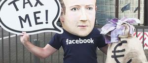 Zahl’ Steuern! Die Aufforderung des Aktivisten mit Zuckerberg-Maske an die global operierenden Onlinekonzerne gilt europaweit.