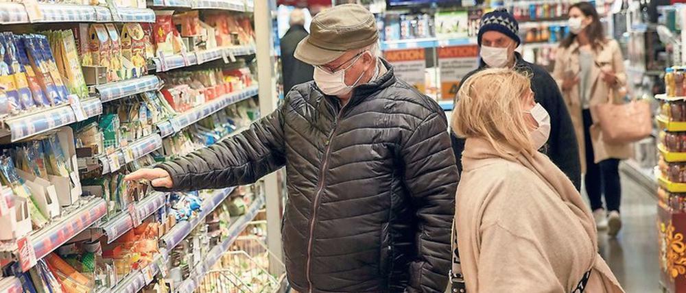 Hinter Masken. Handel, Personal und Kunden tun schon jetzt oft ihr Möglichstes, um sich beim Gang in den Supermarkt nicht mit dem neuartigen Coronavirus zu infizieren.