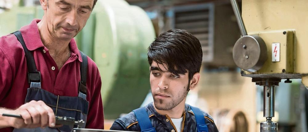 Ausbilder Wolfgang Wonneberger (l) von der Jenaer Feinblech GmbH in Jena (Thüringen) mit dem 19-jährigen Flüchtling Rezwan Waziri aus Afghanistan. 