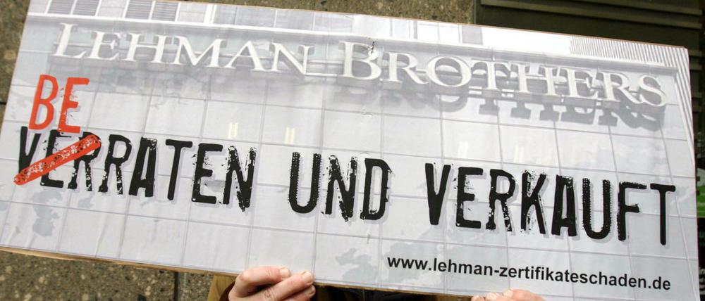 Ein Demonstrant hält 2008 in Düsseldorf ein Protestplakat in den Händen.
