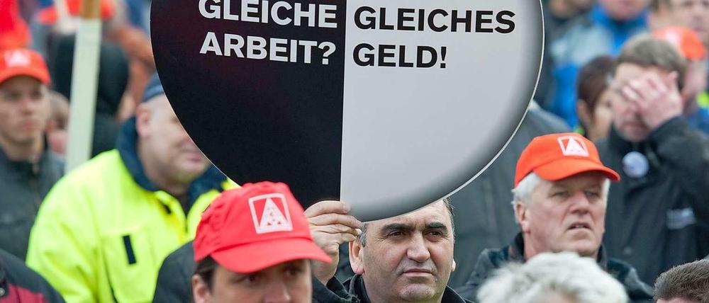 Die Mitarbeiter von Mercedes Benz, die im November 2011 in Sindelfingen demonstrierten, hielten ein rundes Plakat mit der Aufschrift: "Gleiche Arbeit? Gleiches Geld!" in die Höhe.