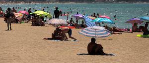 Menschen sonnen sich und schwimmen am Strand von Arenal auf Mallorca.