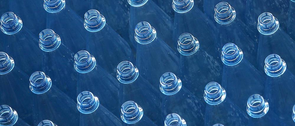 Leere PET-Mehrwegflaschen für Mineralwasser stehen auf einem Transportband einer Abfüllanlage. 