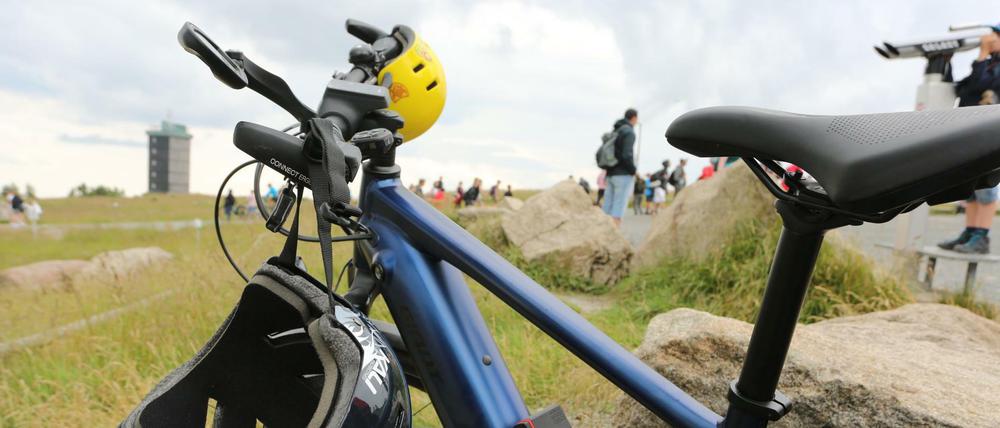 Zwei Helme hängen an einem Fahrrad, das auf dem Brocken steht. (Symbolbild)