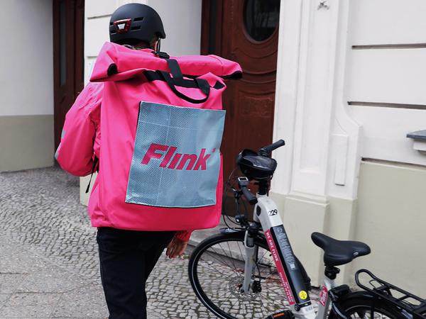 Ein Fahrradkurier des Lieferdienstes Flink steht in Berlin.