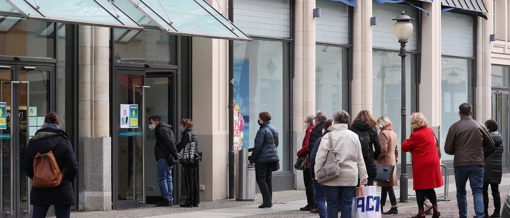 Menschen stehen vor einem Geschäft an (Archivfoto)