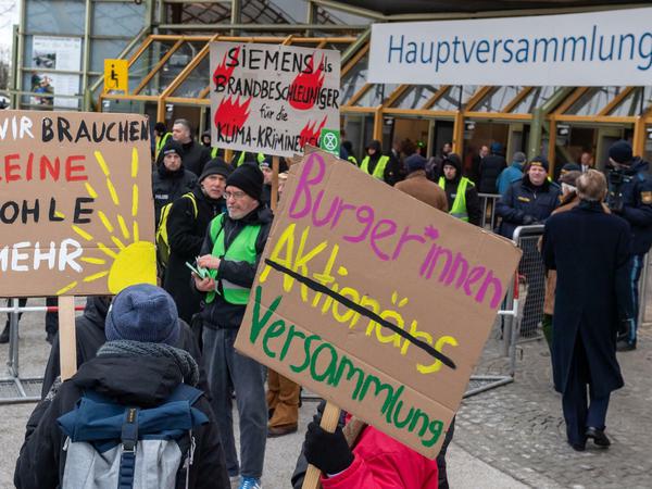 Klimaaktivisten demonstrieren am Haupteingang zu Beginn der Siemens-Hauptversammlung.