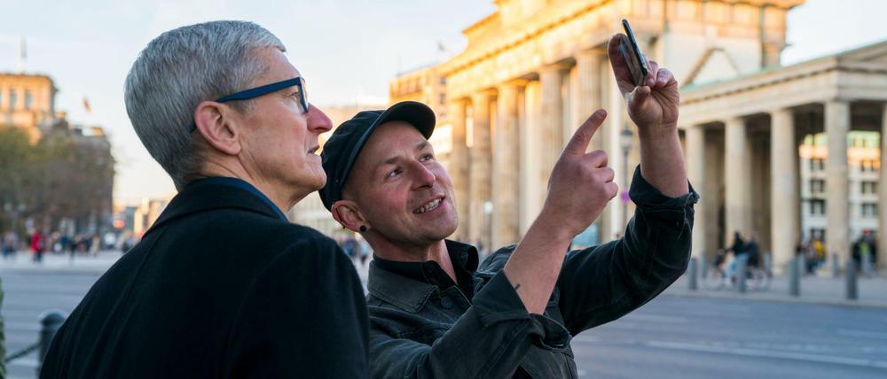 Apple-Chef Tim Cook (links) lässt sich am Brandenburger Tor von Entwickler Peter Kolski das Projekt «MauAR» erklären. Kolski lässt die Berliner Mauer an ihrem historisch korrekten Ort wieder sichtbar werden. 