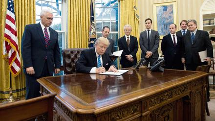 Der weißhaarige ältere Herr rechts neben Trump ist dessen Wirtschaftsberater Peter Navarro.