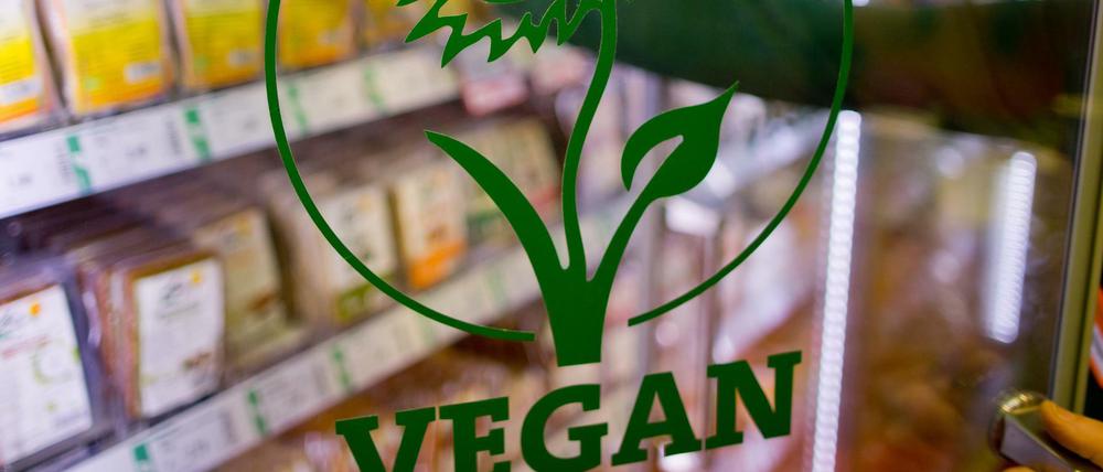 "Vegan" ist auf der Glastür eines Kühlregals mit veganen Produkten in einem Biosupermarkt zu lesen. 