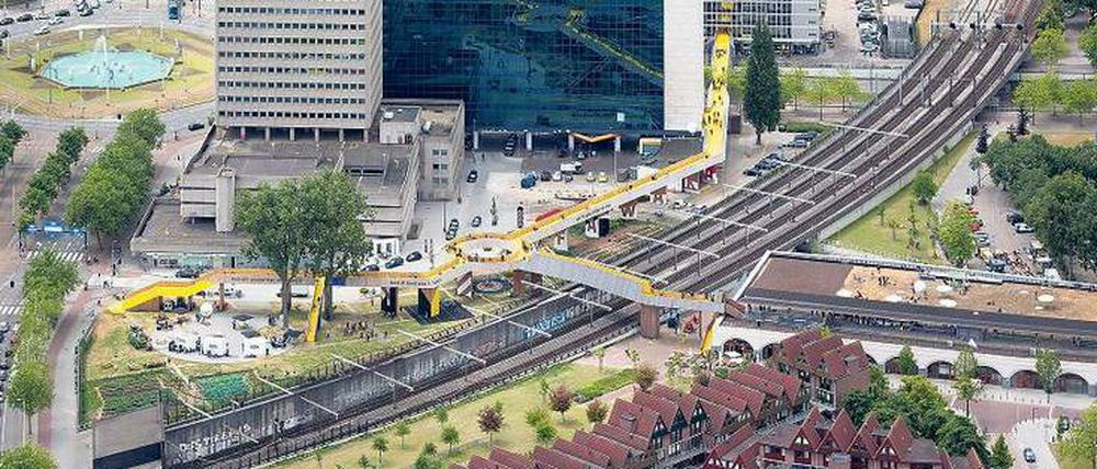 Das gelbe Band. Die „Luchtsingel“ (Luftgracht) verbindet den entstehenden Park Pompenburg (links) und den alten Bahnhof Hofplein (rechts) mit dem Stadtzentrum quer durch den Schieblock (Hintergrund) zum neuen Hauptbahnhof. Der Kreisel markiert das alte Stadtzentrum Rotterdams und korrespondiert mit dem Kreisverkehr Hofplein links im Bild.