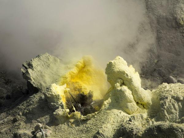 An einer Dampfaustrittsstelle des Vulkans „White Island“ in Neuseeland wird der Gehalt an Schwefelverbindungen gemessen, die das Gestein gelb färben.