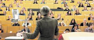 Eine Professorin steht im Hörsaal vor Studierenden.
