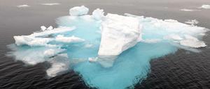 Ein Eisberg und Eisschollen in der Arktis.