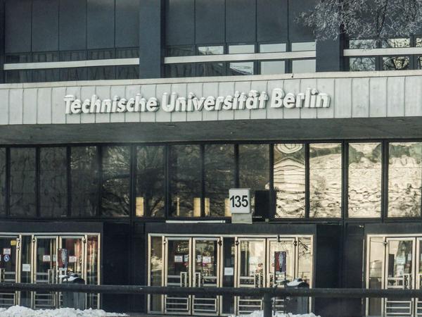 Außenansicht des TU-Hauptgebäudes mit Schneehauben auf dem Schriftzug mit dem Namen der Universität.