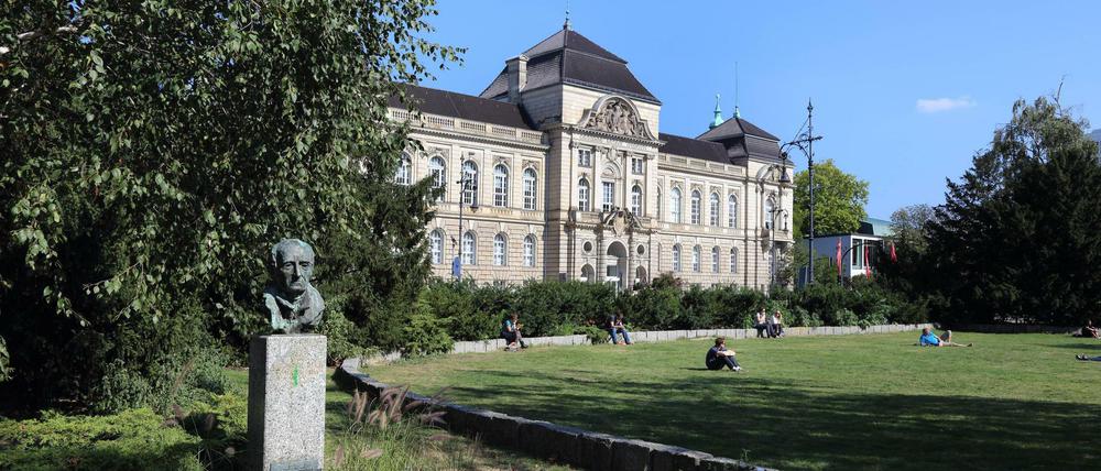 Studierende sitzen auf einer Rasenfläche der Universität der Künste in Berlin.
