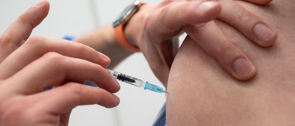 Ein Mitarbeiter eines Impfzentrums verimpft einen Corona-Impfstoff.