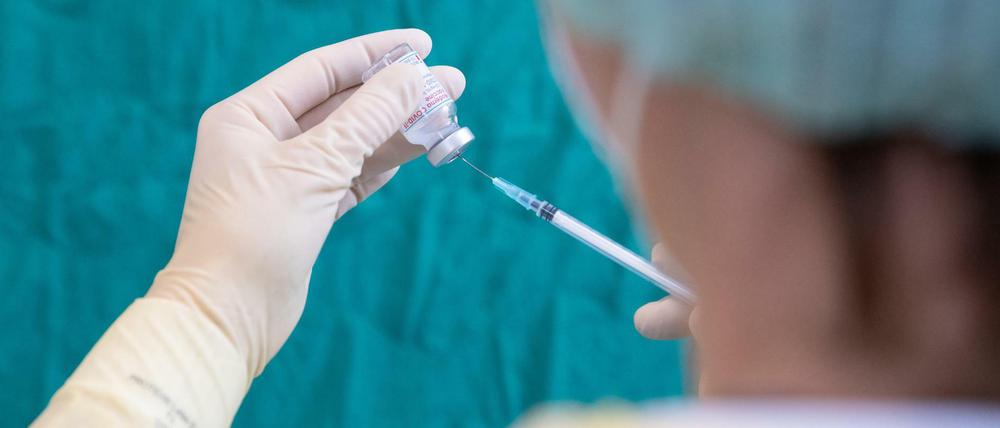 Durch, aber kein Bruch: In die sterile Gummimembran einer Impfstoffampulle sticht hier eine Krankenschwester in Bielefeld, um eine Dosis aufzuziehen.