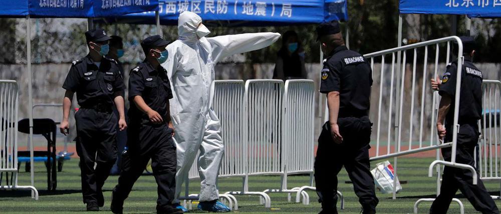 Peking: Ein Arbeiter leitet Sicherheitskräfte an, während sie Barrikaden für die Durchführung von Nukleinsäuretests in einem Stadion aufbauen.