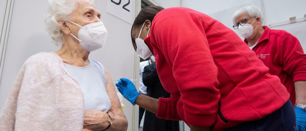 Eine Ärztin impft eine 90-jährige Frau in einem Impfzentrum in Frankfurt gegen das neuartige Coronavirus. Folgen der Erkrankung wären wahrscheinlich schwerwiegender als mögliche Folgen der Impfung.