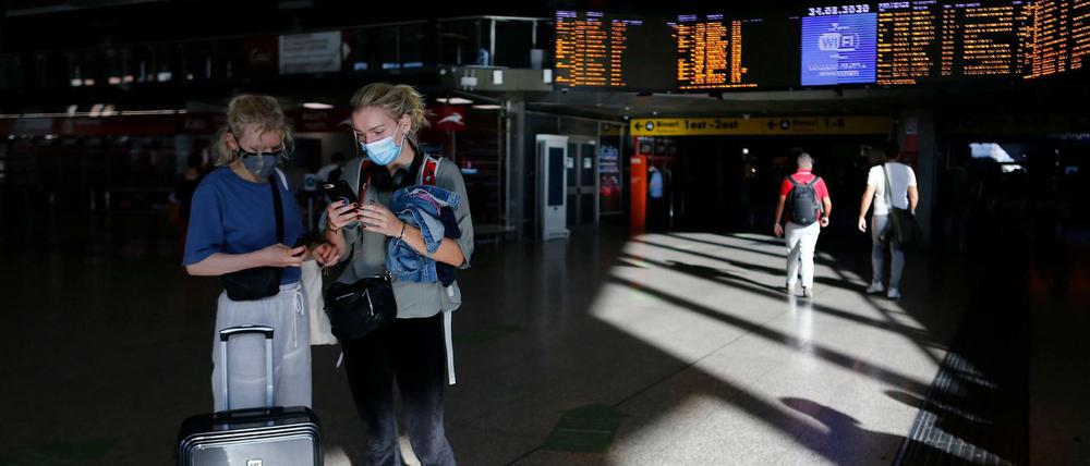 Reisende tragen Mundschutz im Hauptbahnhof Termini in Rom.