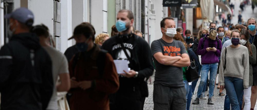Menschen mit Mundschutz stehen in Prag an, um sich auf das Coronavirus testen zu lassen.
