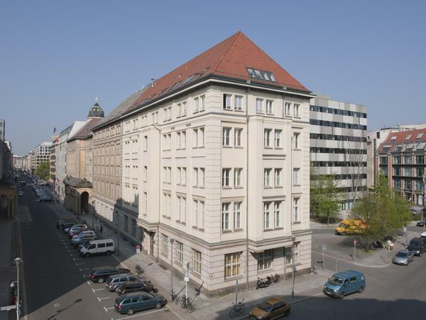 Ein vierstöckiges historisches Gebäude mit einem modernen Anbau im Berliner Innenstadtbereich.