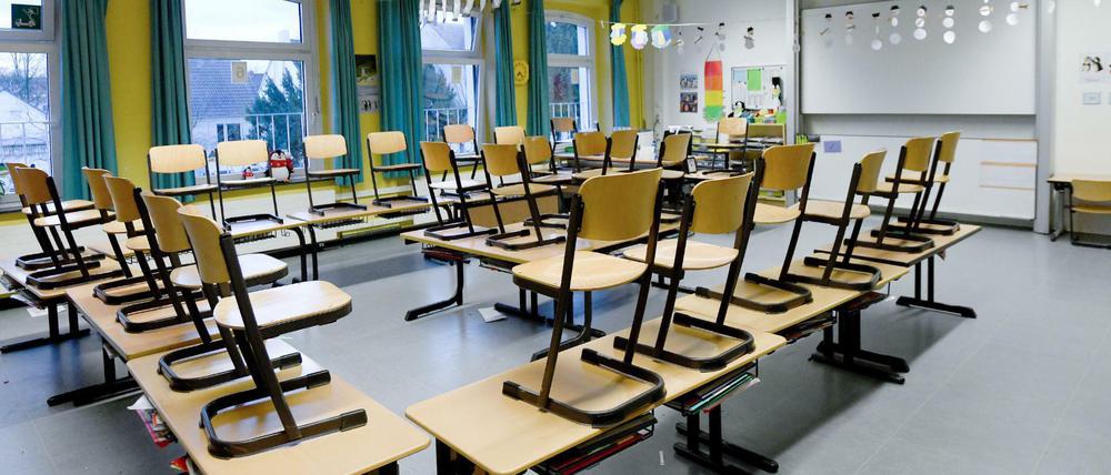Hochgestellte Stühle in einem leeren Klassenraum.