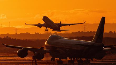 Ein Flugzeug startet im letzten Licht der Sonne am Flughafen Frankfurt.