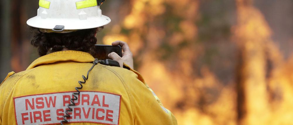 Feuer in Australien. Ein Feuerwehrmann nimmt im Januar 2020 mit seinem Smartphone einen kontrollierten Brand in der Nähe von Tomerong auf.