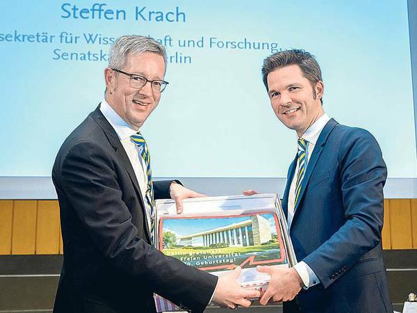 Eine Geburtstagstorte überreichte Staatssekretär und Alumnus Steffen Krach (r.) Universitätspräsident Günter M. Ziegler.
