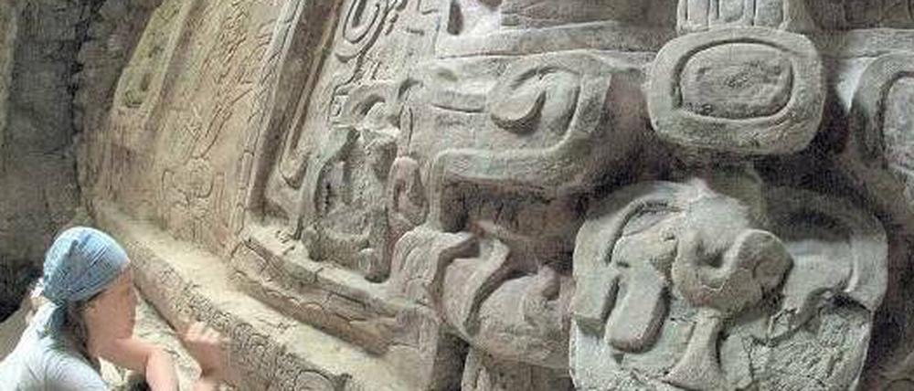 Das Maya-Relief in Guatemala zeigt drei Figuren, die mit Insignien des höchsten gesellschaftlichen Ranges in der Maya-Kultur geschmückt sind.