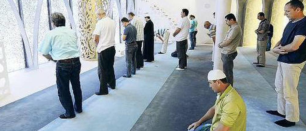 Muslimische Männer stehen in einer Moschee in Bayern.
