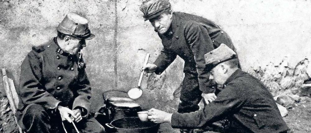 Französische Soldaten bereiten sich am Rande des Schlachtfelds eine Mahlzeit zu.