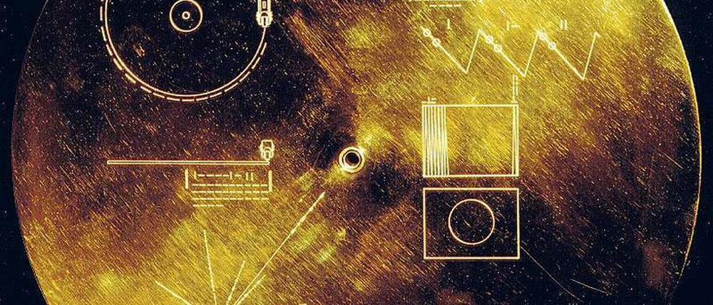 Goldene Schallplatte der Menschheit. An Bord der interstellaren Sonden „Voyager 1“ und „Voyager 2“ befinden sich vergoldete Kupferplatten mit Bild- und Audiodateien. Die hier abgebildete Hülle zeigt dem außerirdischen Benutzer, wie er die Platten abspielen sollte. Praktischerweise ist auch eine Abspielnadel für die „Golden Record“ dabei. 