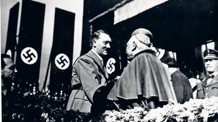 Das Bild zeigt Hitler beim Händeschütteln mit einem katholischen Bischof.