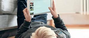 Ein Junge schaut Youtube-Filme auf einem Tablet-Computer.