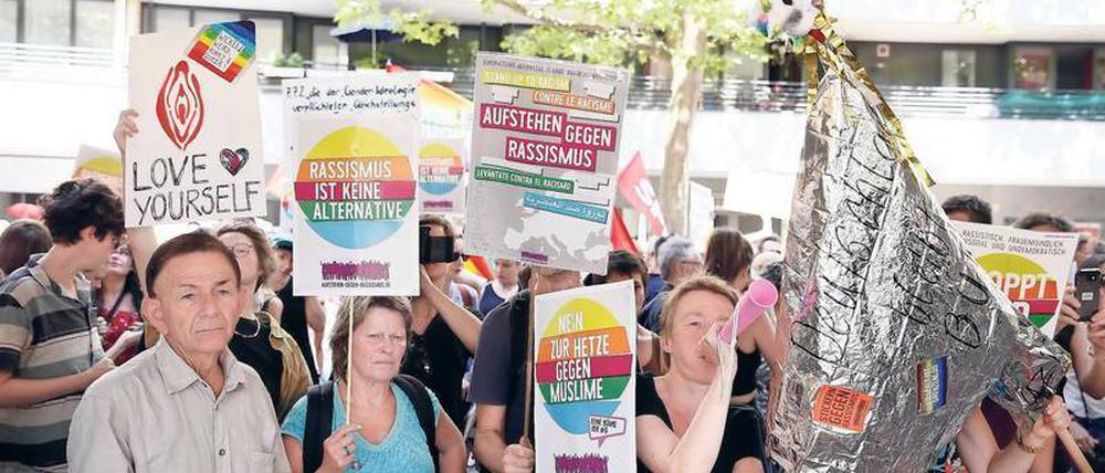 Gegendemonstranten reagieren mit Plakatparolen wie "Rassismus ist keine Alternative" auf einen von der AfD organisierten „Frauenmarsch“.