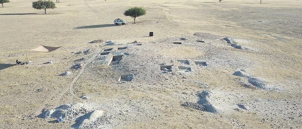 Drohnenbild einer archäologischen Grabungsstätte in einer kargen afrikanischen Landschaft.